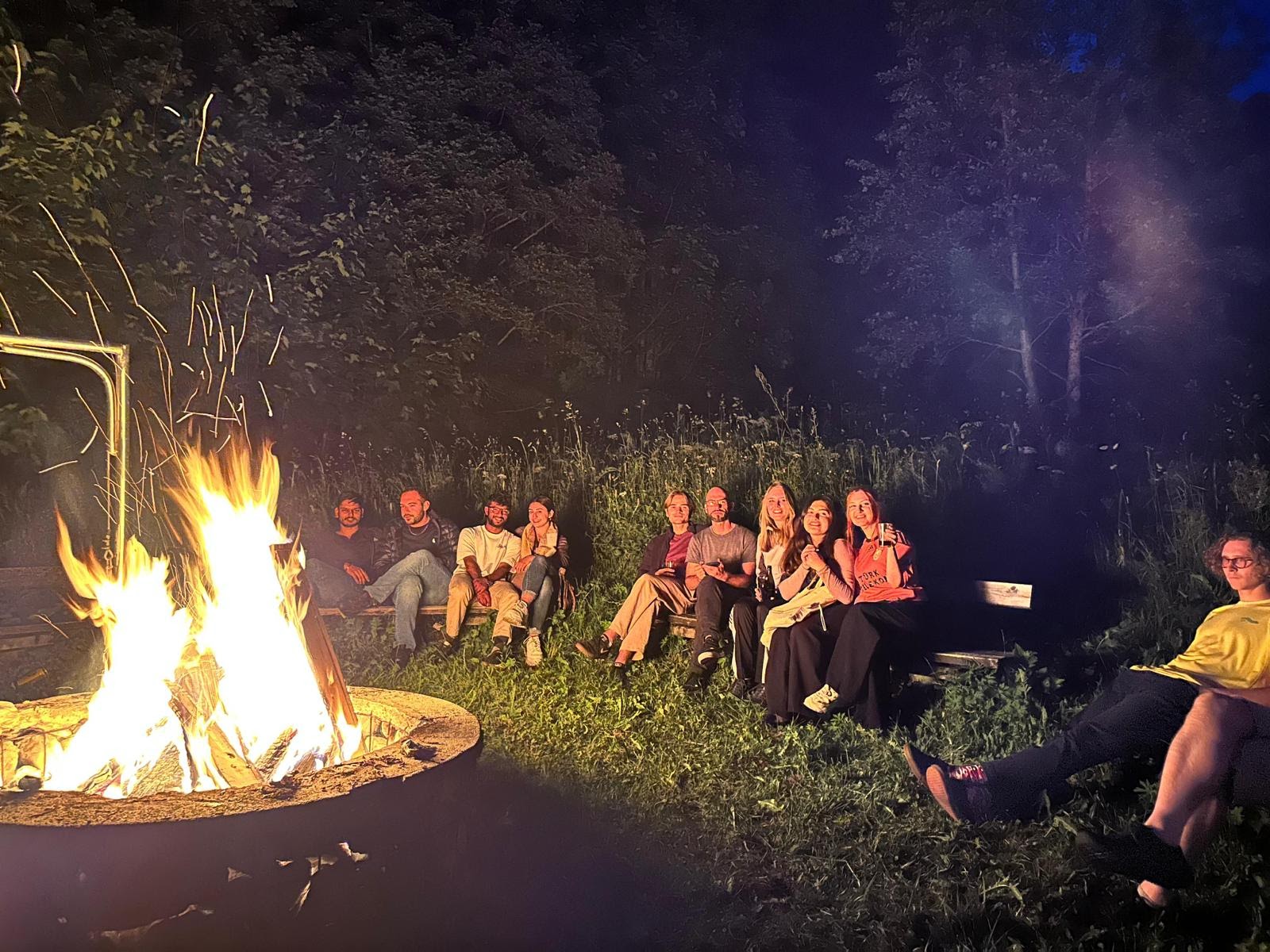 Gruppe bei Nacht rund um ein Lagerfeuer